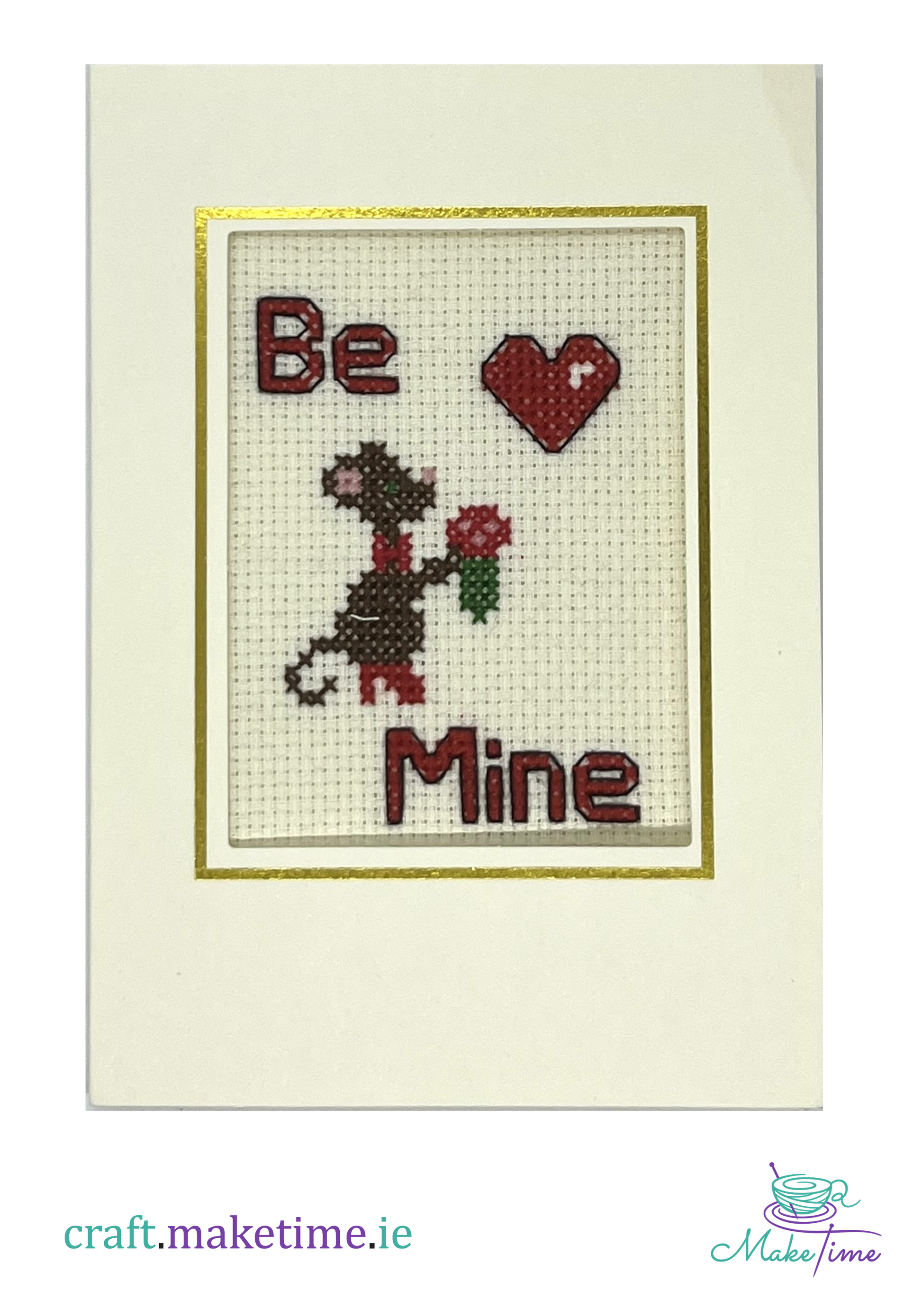 Cross-stitched design with a mouse holding a heart and flowers, text 'Be Mine', on a white background.