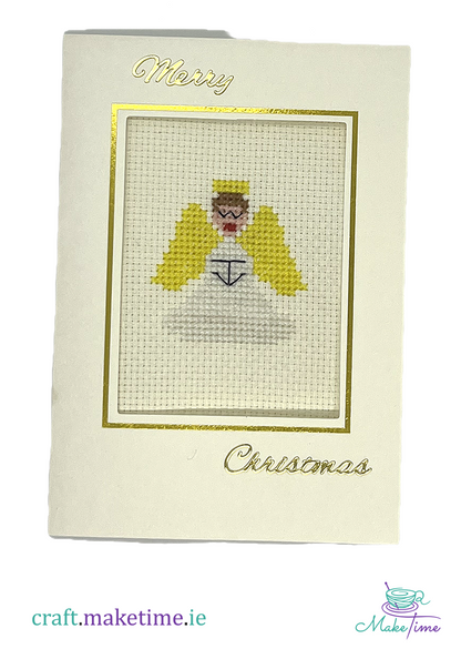Cross-stitched angel on a Christmas card with 'Merry Christmas' text.