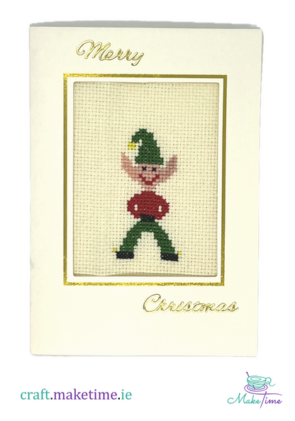 Cross-stitched Christmas elf design on a card with 'Merry Christmas' text.