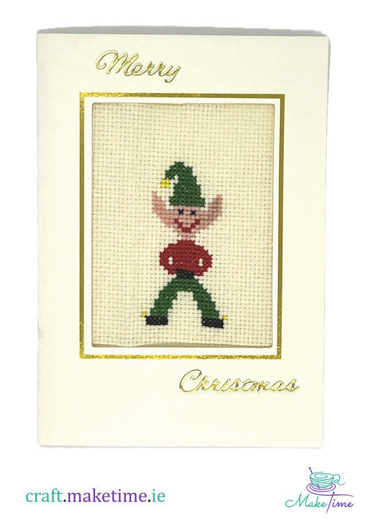 Cross-stitched Christmas elf design on a card with 'Merry Christmas' text.