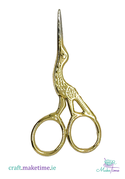Gold scissors with stork decoration on a white background