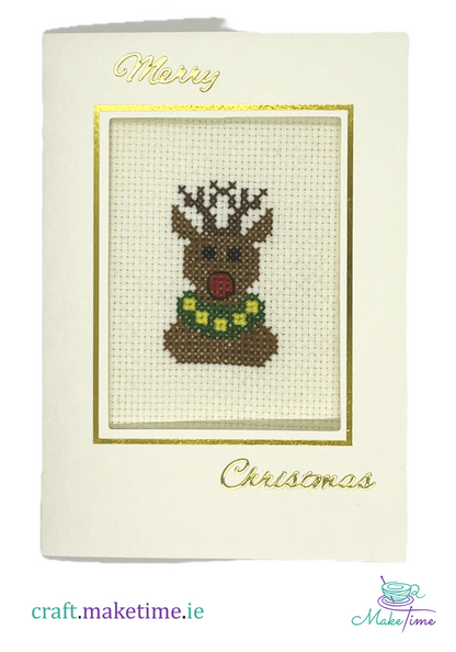 Cross-stitched Rudolf the red nosed reindeer design on a Christmas card with 'Merry Christmas' text.