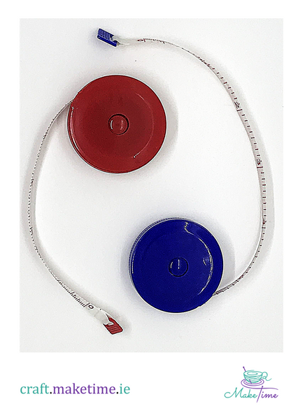 Retractable measuring tape with red and blue covers on a white background